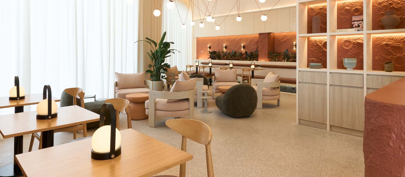 A warm hospitality lounge — terracotta feature wall, soft lighting and sculptural seating